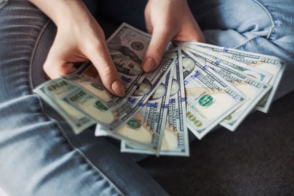 woman holding cash bill