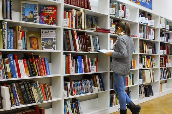 girl looking at the book in library