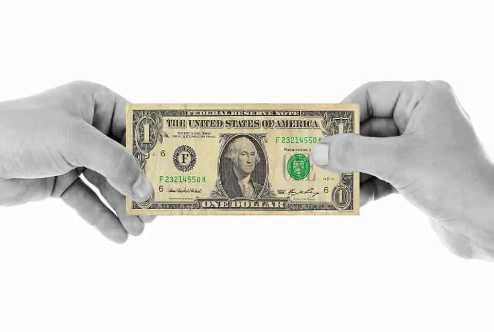 two hands holding one us dollar bill